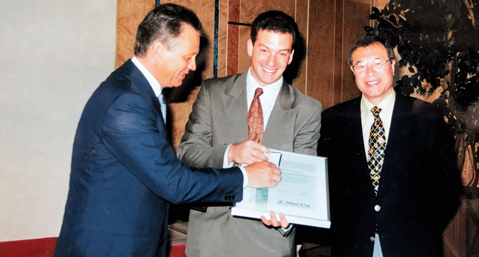 Rainer Mayer y Peter Mayer entregando a Fernando Ferradás en 1995 un certificado por los 35 años de colaboración con los agentes argentinos de la empresa Dimatex.